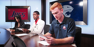 Journalism students working on news scripts in the campus studio.