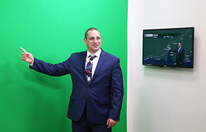 Man pointing at green screen in weather center,