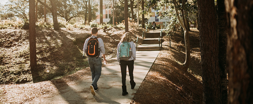 Two students walking toward the arts and sciences building.