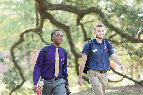 Two male students walking across campus.