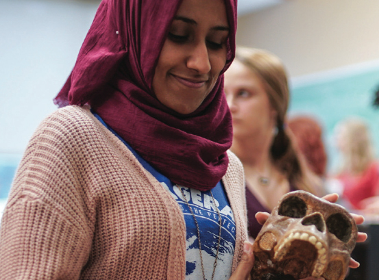 Student looking down at skull