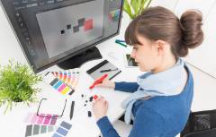 Woman working with color samples at desk.