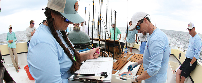 Students collecting specimens on a boat out on the water.