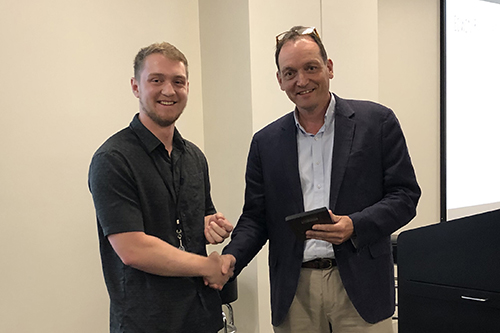 Triston Cooper, left, receives the Edwin R. Hughes Memorial Award from Christopher Davies, Ph.D., associate dean for research.