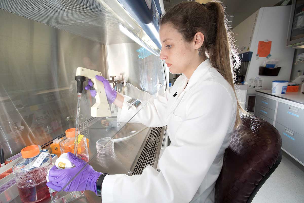 Photo of BMS graduate student using research equipment in the lab
