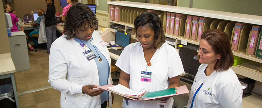 Three nurses in the Bachelors of Science in Nursing (BSN) Program reviewing a chart.