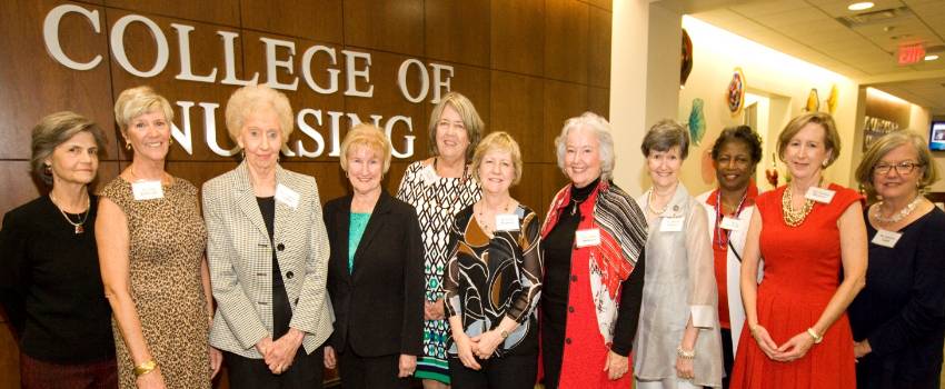 College of Nursing Alumni standing in front of the CON sign