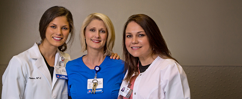 Three Doctor of Nursing Practice (DNP) nurses with their arms around each other in the Emergency Department