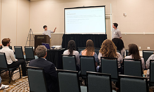 Students presenting their undergraduate research in front of class.