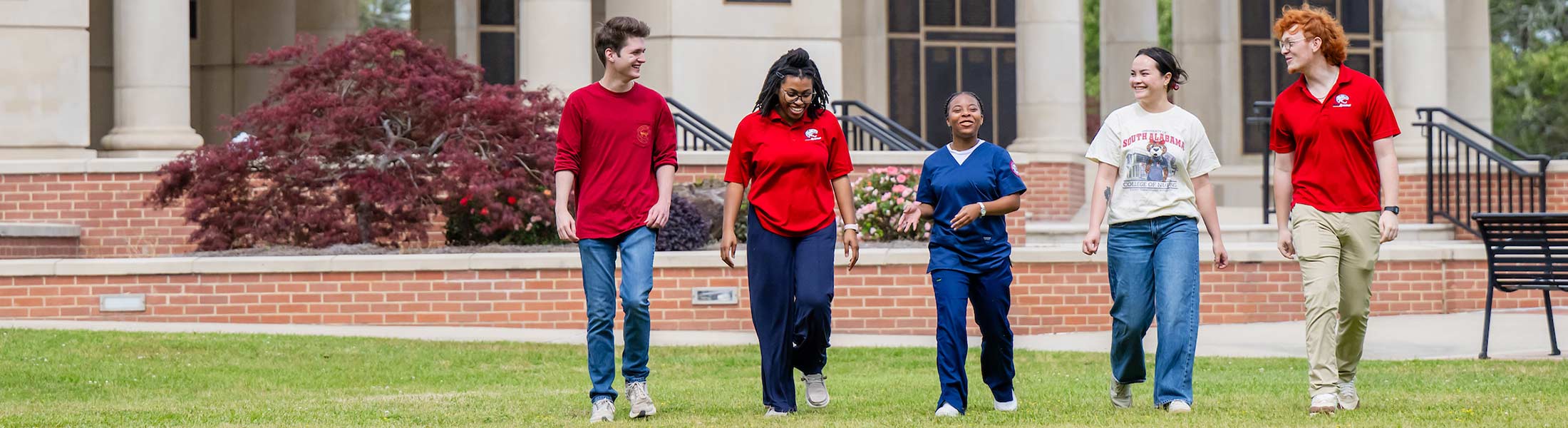 Five students on campus walking in front of Moulton Tower.