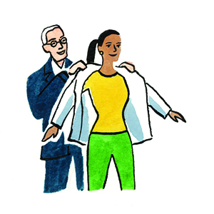 Professor putting whitecoat on medical student.