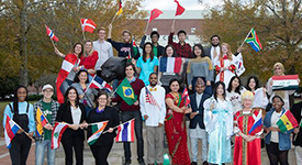 International Students holding flags in front of Mitchell Center