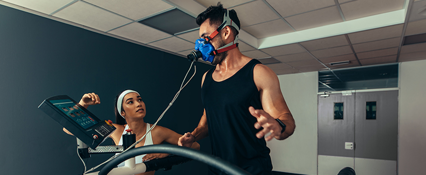 Man running on treadmill with breathing machine on.
