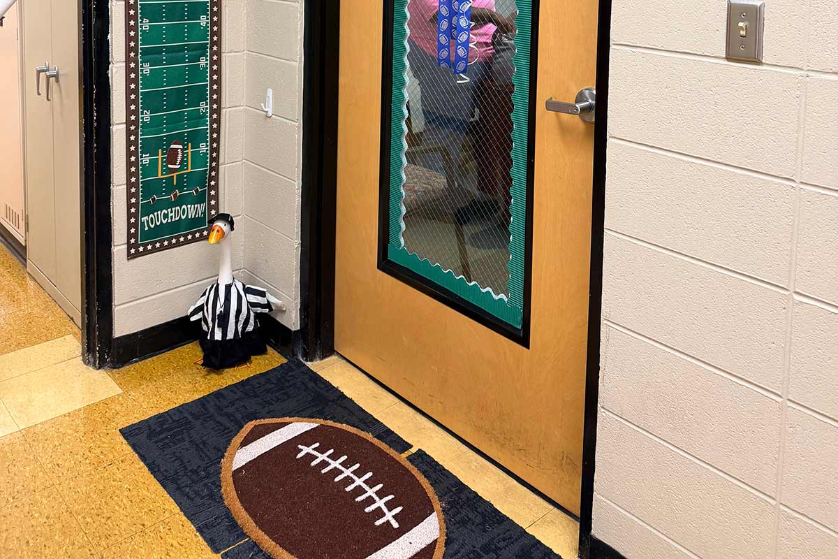 Goose dressed in referee uniform with football mat outside of an office. Goose dressed in referee uniform with football mat outside of an office.